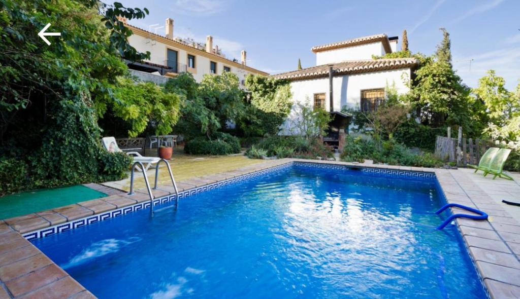 a swimming pool in front of a house at La Posada del Gato in Monachil