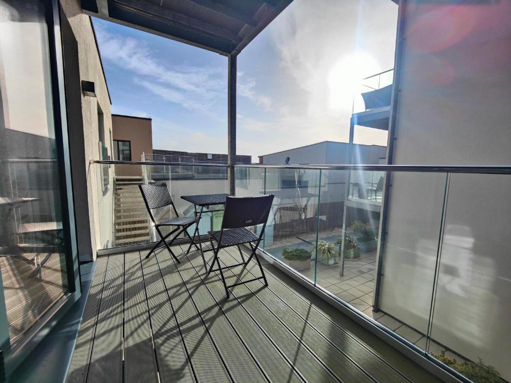 a balcony with two chairs and a table on it at 8 Putsborough - Luxury Apartment at Byron Woolacombe, only 4 minute walk to Woolacombe Beach! in Woolacombe