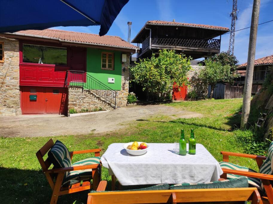 una mesa con un bol de frutas y botellas de vino en 10A04 Casa Petacos, en Pravia
