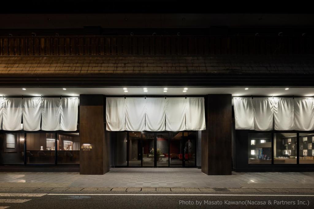 - un bâtiment avec des rideaux blancs à l'avant dans l'établissement Atarayo Nishiizu Onsen, à Izu