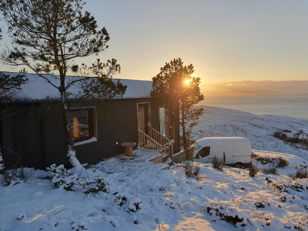 van zaparkowany przed domem w śniegu w obiekcie Stunning 1-Bed tiny home in Isle of Skye w mieście Elgol