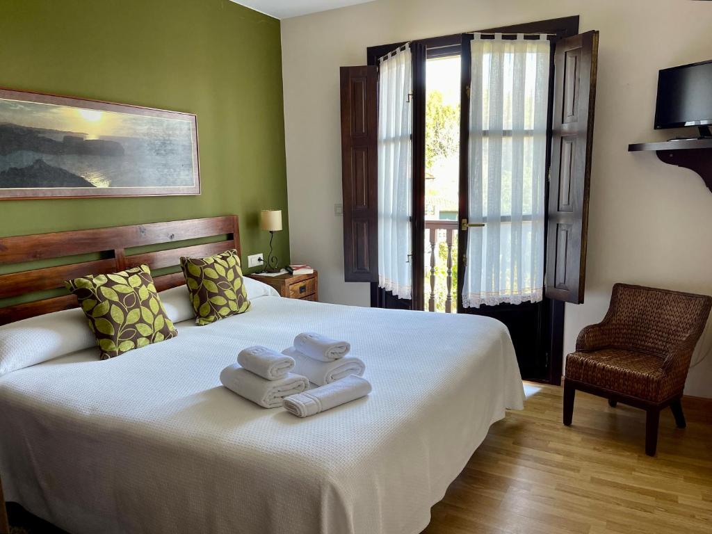 a bedroom with a bed with towels on it at Hotel Rural El Texeu in Llanes