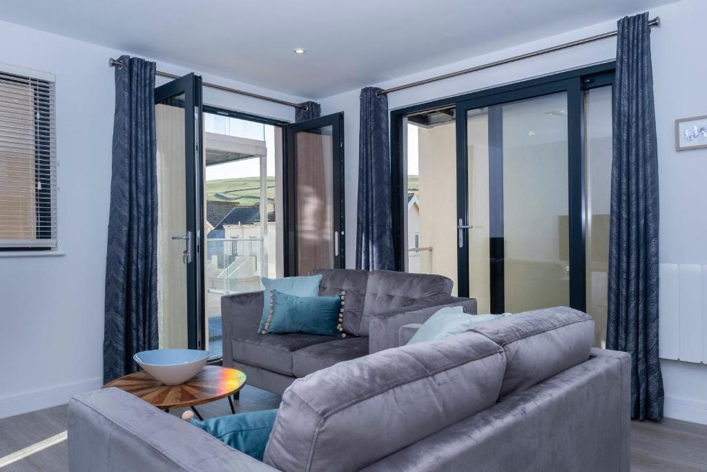 a living room with a couch and a table at 6 Putsborough - Luxury Apartment at Byron Woolacombe, only 4 minute walk to Woolacombe Beach! in Woolacombe