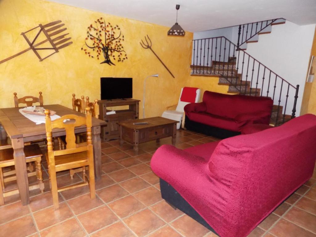 sala de estar con sofá rojo y mesa en CASAS RURALES LAS ERAS 1 Y 2, en Santa María de Riaza