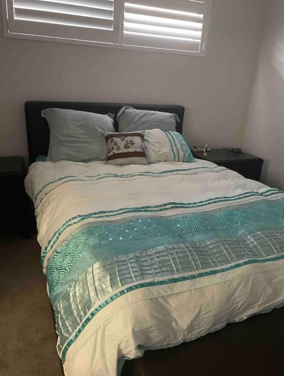 a large bed in a bedroom with avertisement at Room on Woodville in Perth