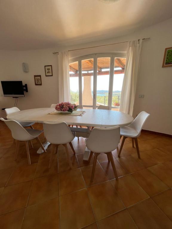 a dining room with a table and chairs and a window at Casa Le Cicale in Porto Istana