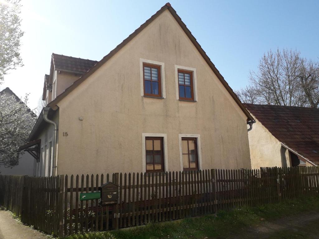 une maison avec une clôture en bois devant elle dans l'établissement Ferinwohnung an der Promnitz Radeburg, à Radeburg