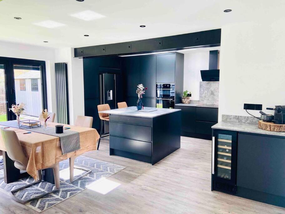 a kitchen with a table and a dining room at The Ely Retreat in Ely