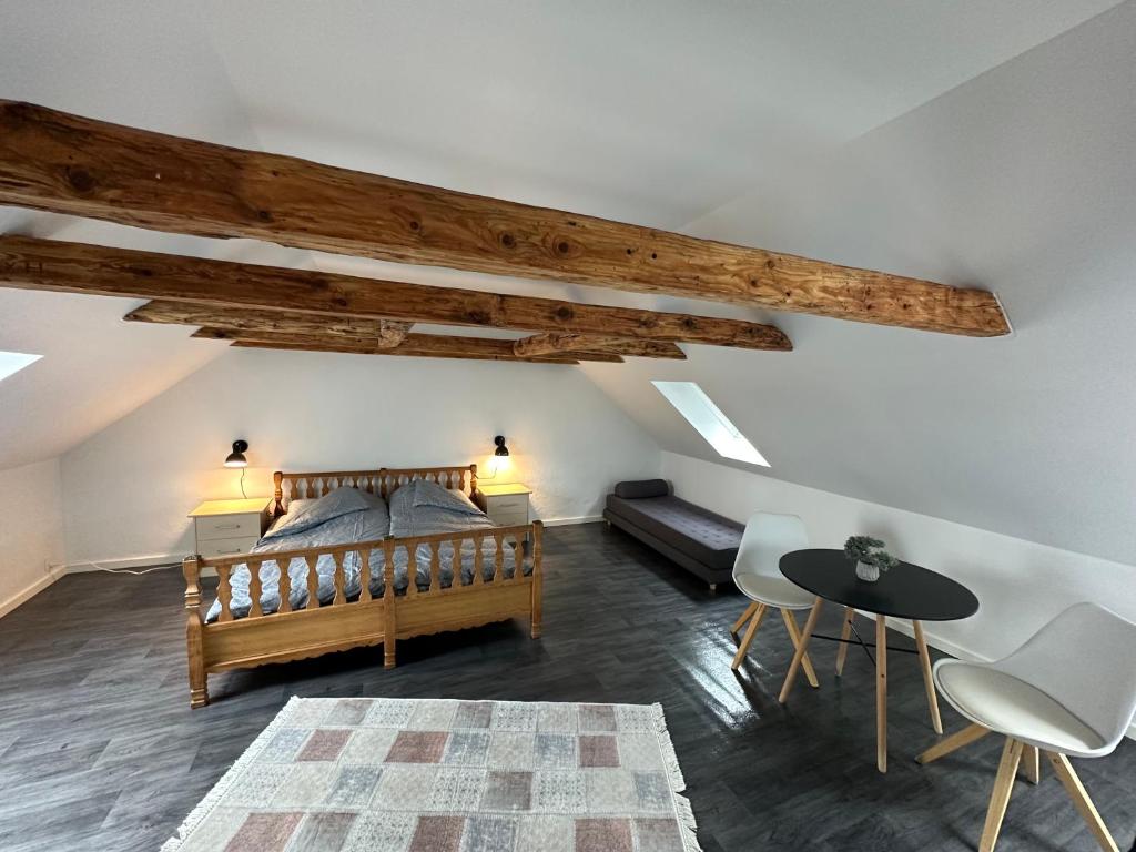 a bedroom with a bed and a table and chairs at Attic Room in Korsør