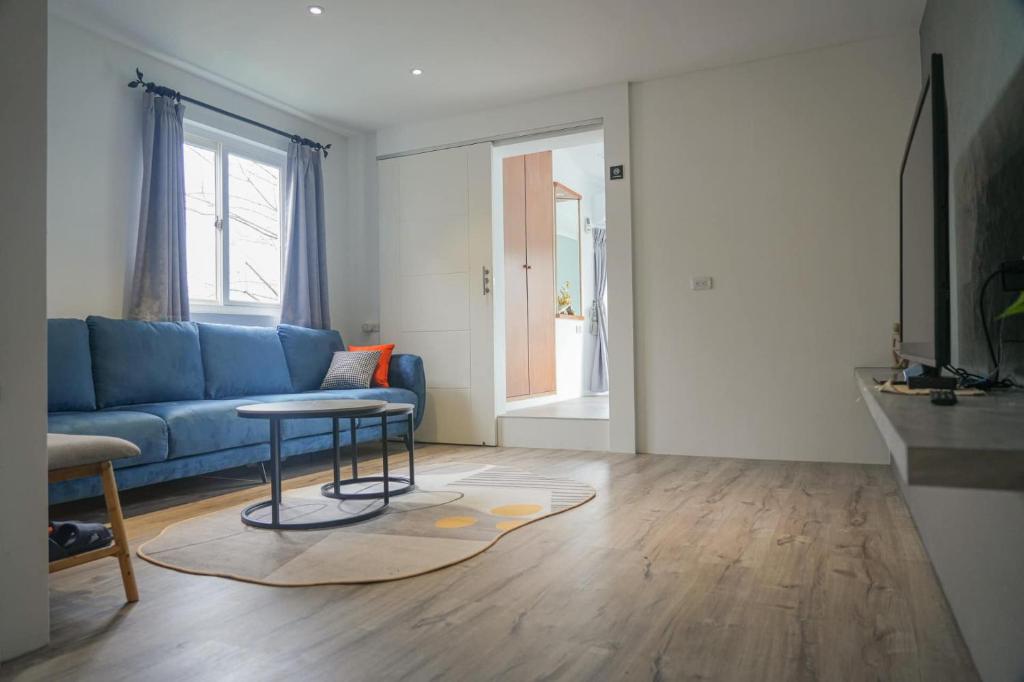 uma sala de estar com um sofá azul e uma mesa em Gegbyan em Ch'ia-la