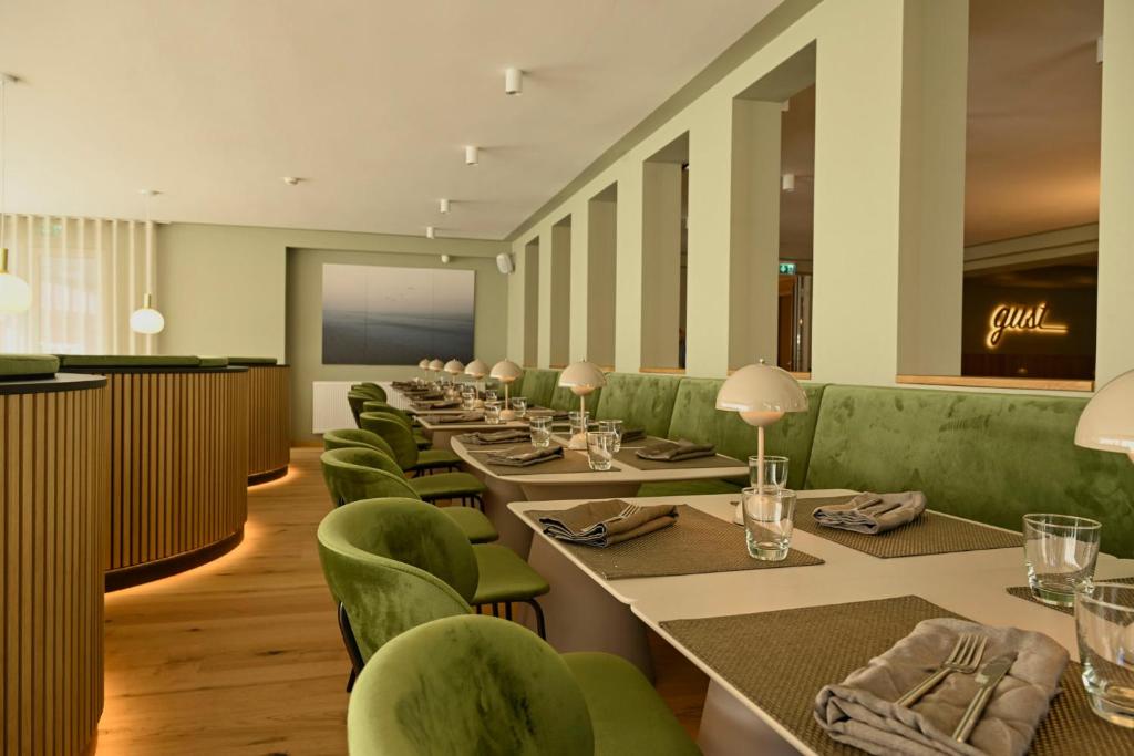 a row of tables and green chairs in a restaurant at Hotel Atlantic Juist in Juist