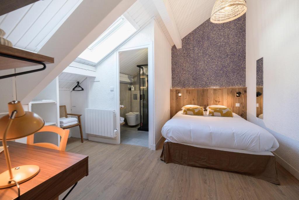 ボーフォールにあるHôtel Maison Doronのベッドルーム(大型ベッド1台付)、バスルームが備わります。