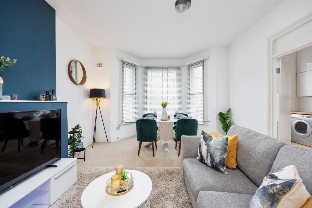 a living room with a gray couch and a table at Stylish Apartment Opposite Westfields in London