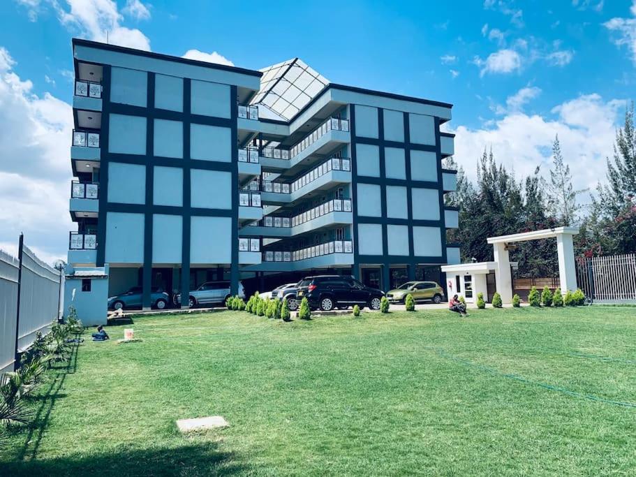 a large building with a yard in front of it at Arabel's Place 1 Bedroom California Plaza Nanyuki in Nanyuki