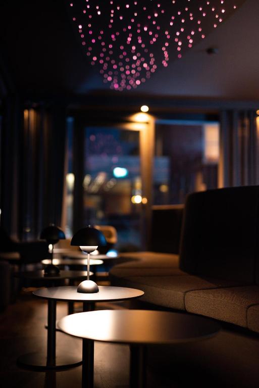 a room with a couch and tables and lights at Hotel Atlantic Juist in Juist
