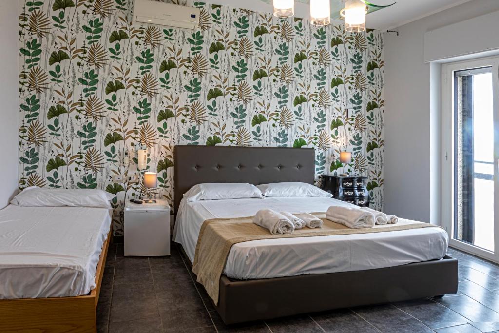 マルゲリータ・ディ・サヴォイアにあるB&B Bellavistaの花柄の壁紙を用いたベッドルーム1室(ベッド2台付)