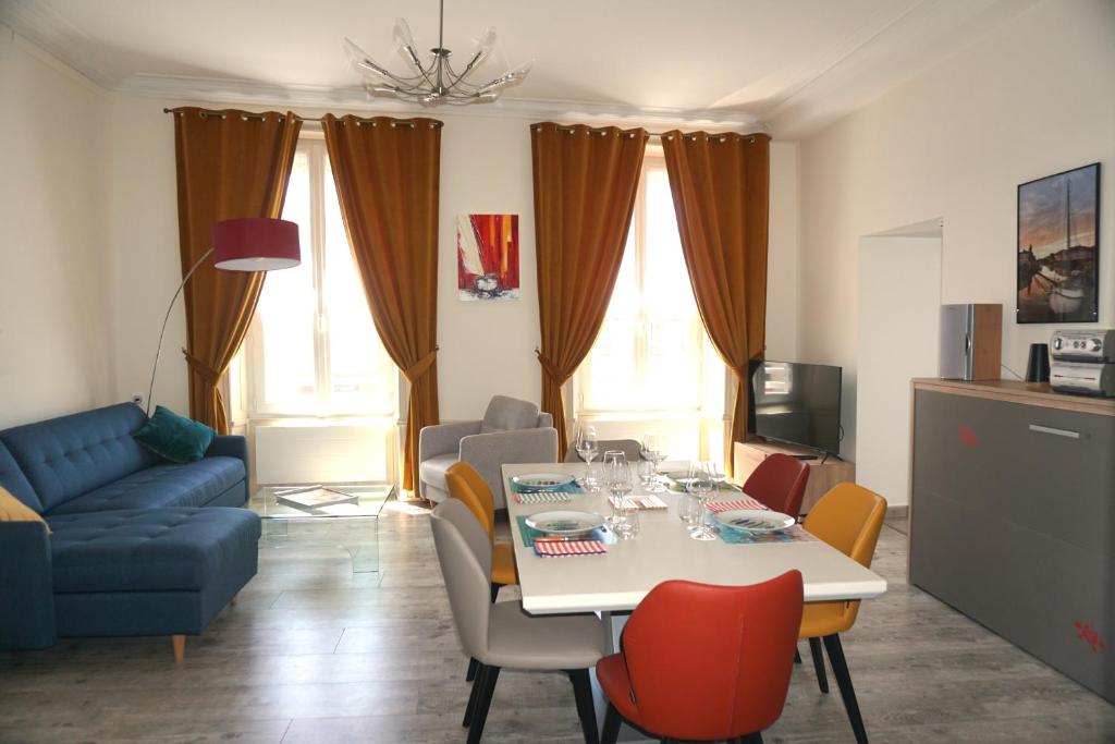 uma sala de estar com uma mesa e um sofá azul em Un trois étoiles entre La Rochelle et les marais poitevin em Marans