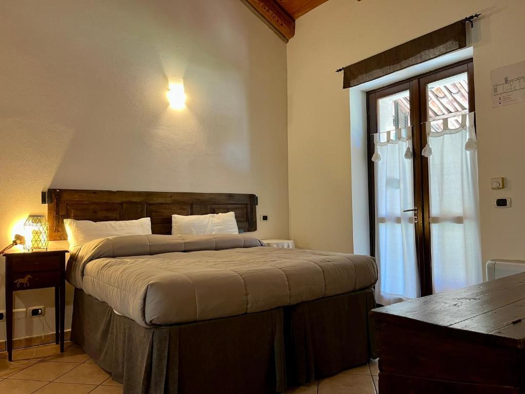 Un dormitorio con una cama grande y una ventana en La Cascina Del Castello, en Asti