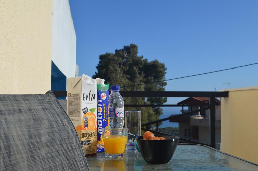 a table with a glass of orange juice and drinks at Not a Villa in Roussospítion