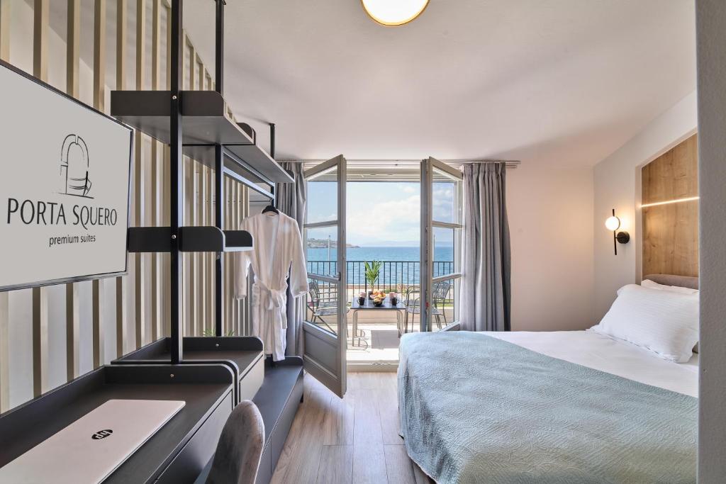 Habitación de hotel con cama y balcón en PORTA SQUERO Premium Suites, en Rethymno