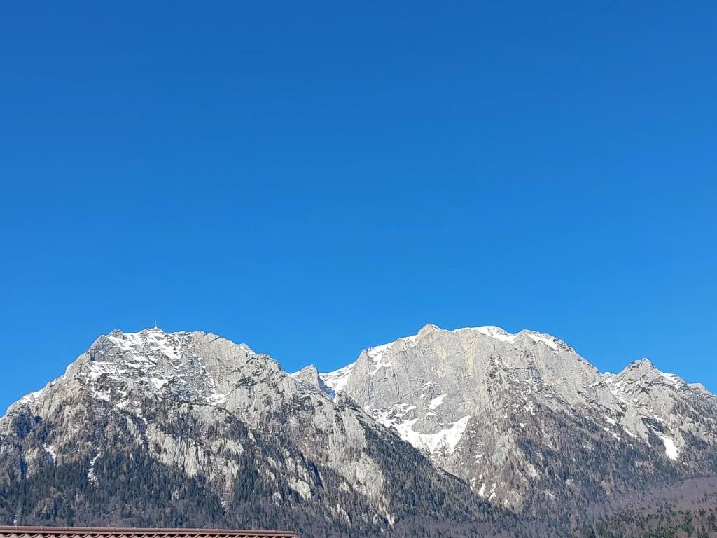 a snow covered mountain range with a blue sky at Casa Kasandra in Buşteni