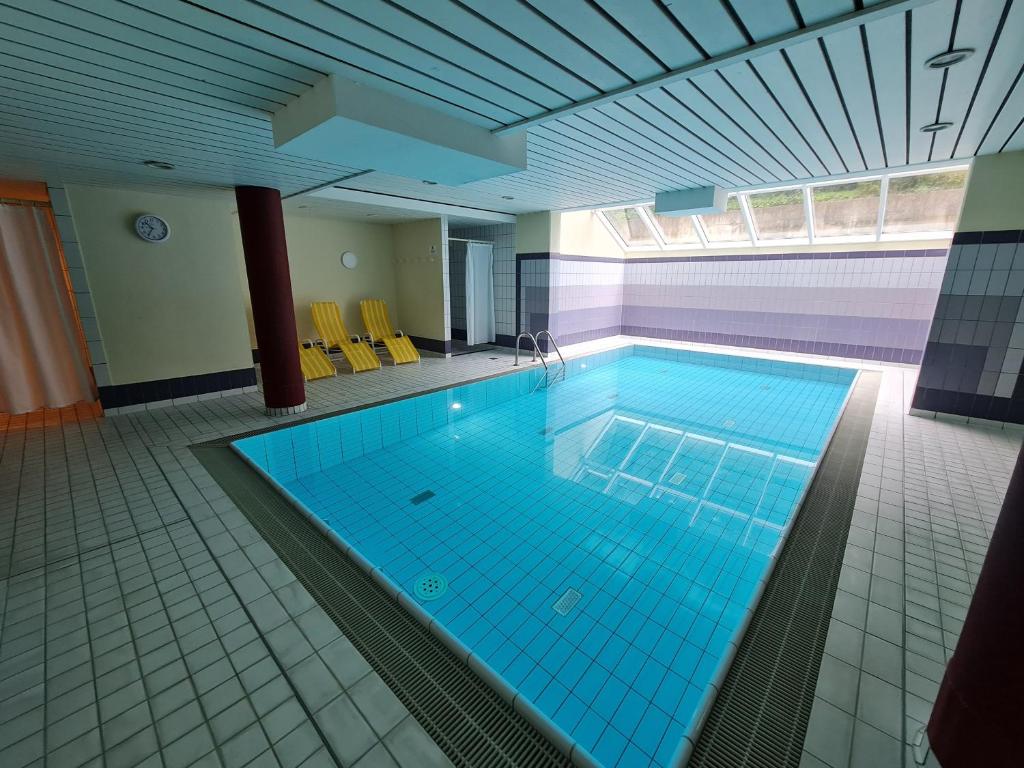 a large swimming pool with blue tiles in a building at Villa a cappella in Binz