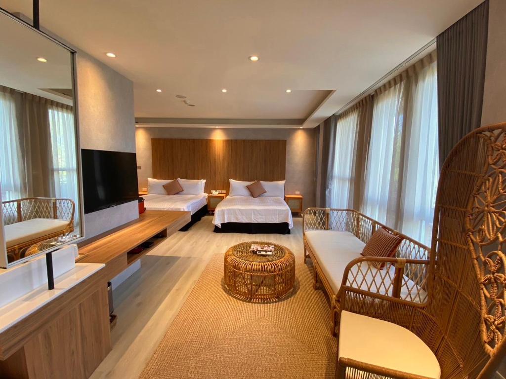 a hotel room with two beds and a flat screen tv at Cingjing Florence Resort Villa in Ren&#39;ai