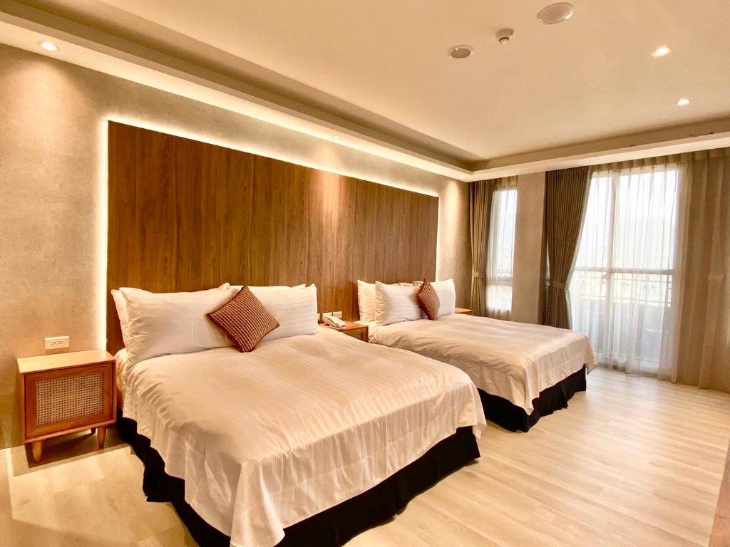 a hotel room with two beds in a room at Cingjing Florence Resort Villa in Ren&#39;ai