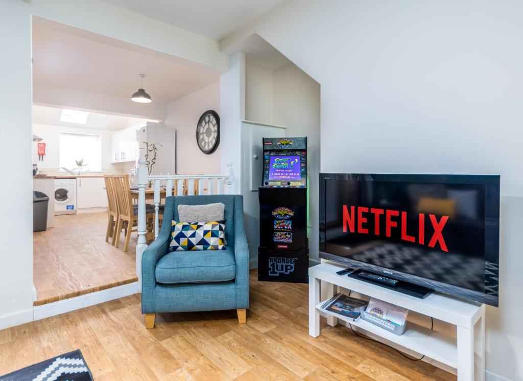 un soggiorno con TV e sedia blu di Relaxing Retreat Perfect For Longer Stays a Southampton