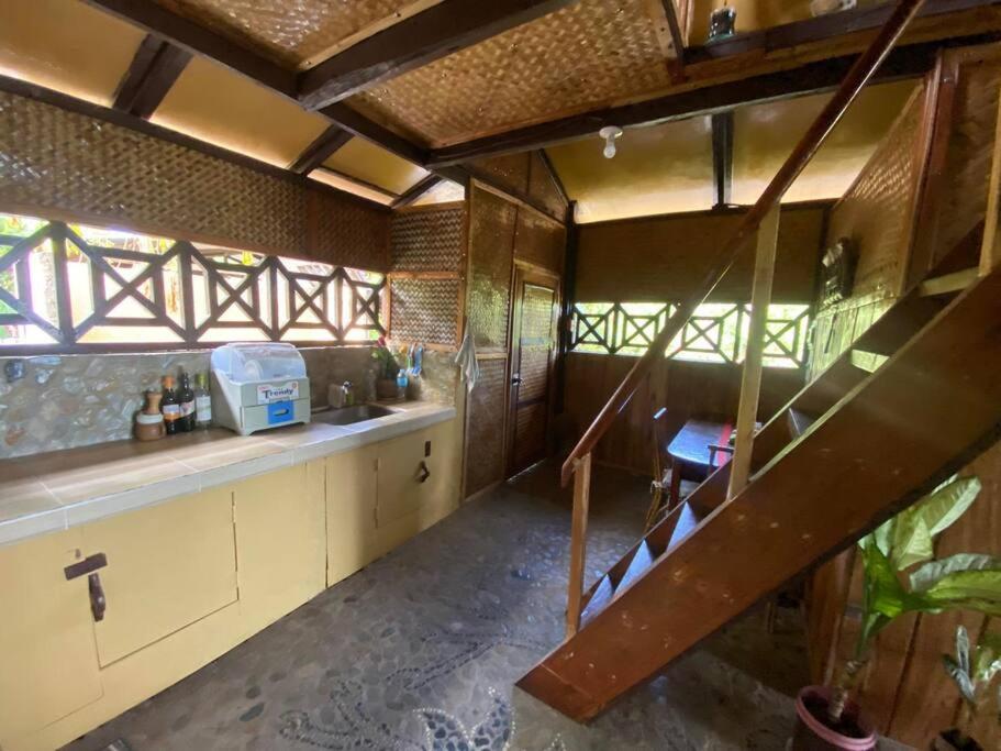 eine Küche mit einer Wendeltreppe in einem Haus in der Unterkunft Auntie Mina's Beach Cabins in Puerto Princesa