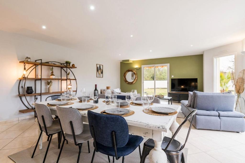 une salle à manger avec une table et des chaises blanches dans l'établissement Le 17BIS, à La Chevrolière