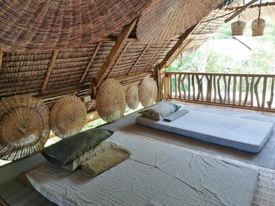 um quarto com uma cama numa cabana de palha em Balay Asiano Cabin em Puerto Princesa