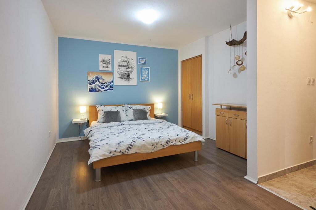 a bedroom with a bed and a blue wall at Apartment Blue in Poreč