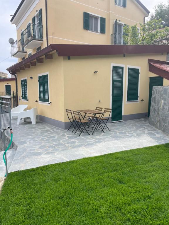 a patio with chairs and a table in front of a house at Cà di Giaco lodge in Moneglia