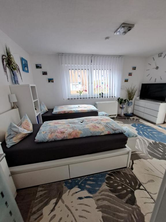 a bedroom with two beds and a tv in it at Ferienwohnung Galina 1 in Rockenhausen