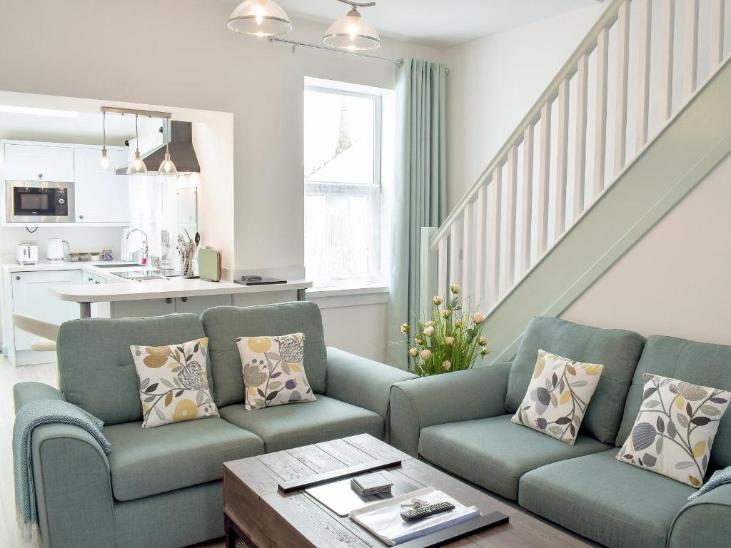 a living room with a couch and a table at Miners Cottage in Girvan