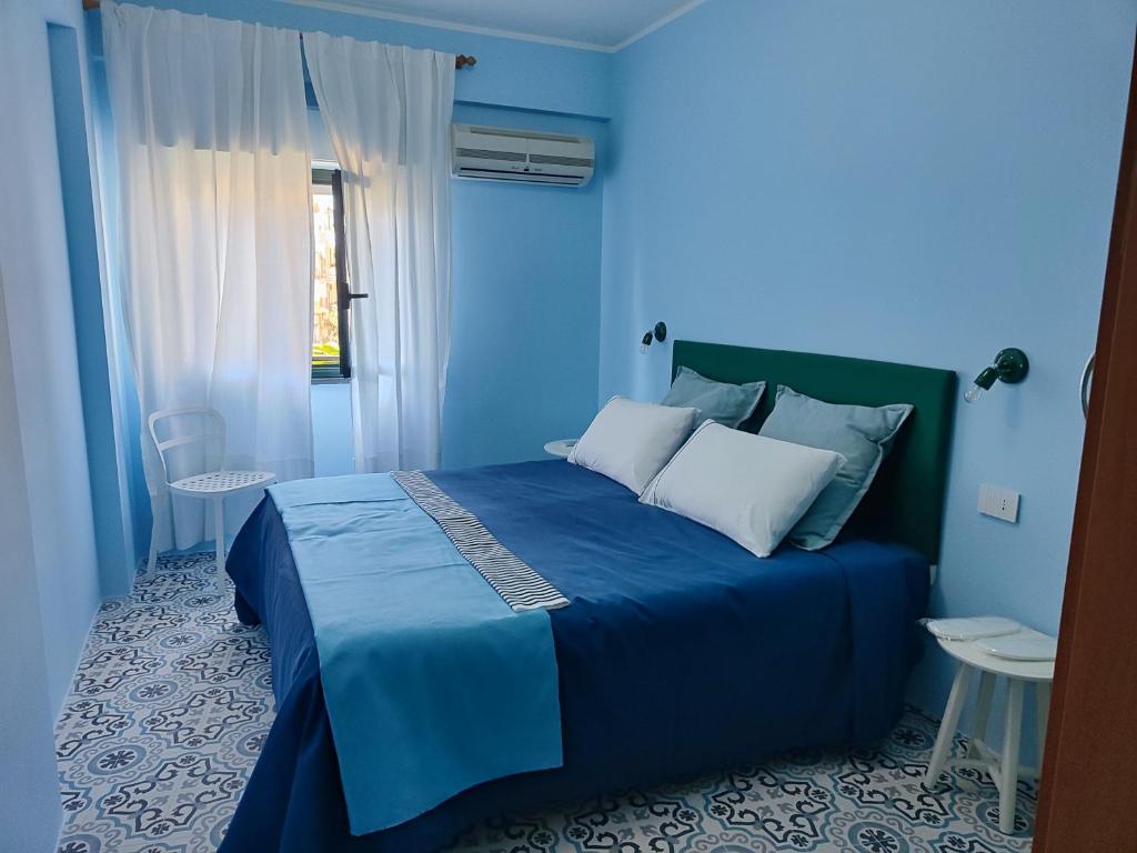 a blue bedroom with a blue bed with white pillows at Case Borgo Vacanze in Letojanni