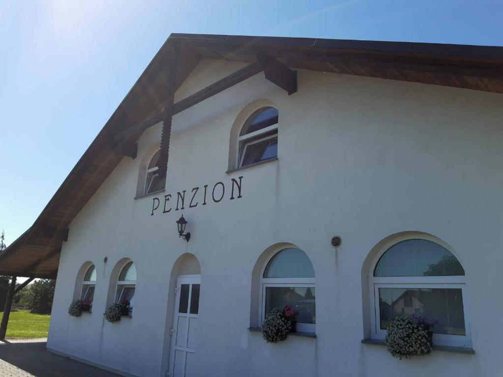 a white building with a sign that reads permission at Penzion Cerhenice in Cerhenice