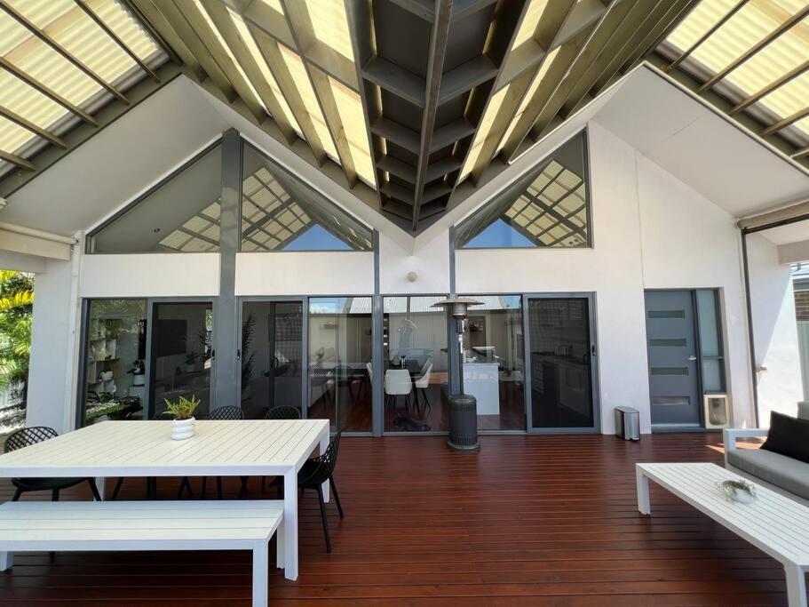 een open woonkamer met een witte tafel en banken bij Stylish 3BR home with outdoor entertaining in Oaklands