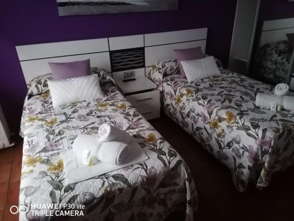 two beds sitting next to each other in a room at Pensión Boavista in Portomarin
