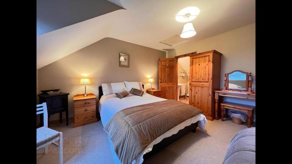 1 dormitorio con cama, escritorio y piano en Asdee House, en Bushmills