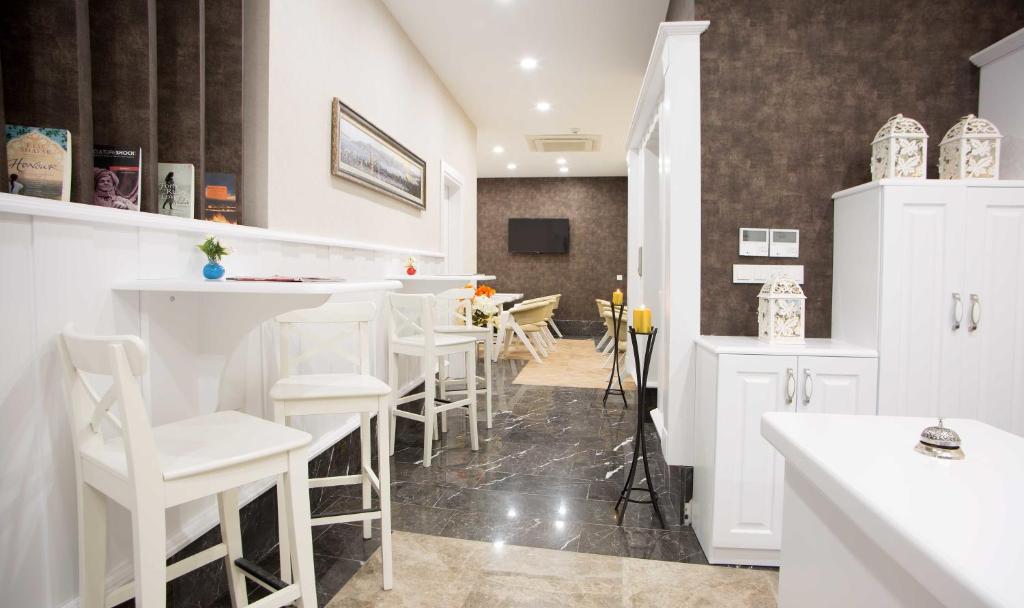 eine Küche mit einer Bar mit weißen Stühlen in der Unterkunft Astan Hotel Taksim in Istanbul