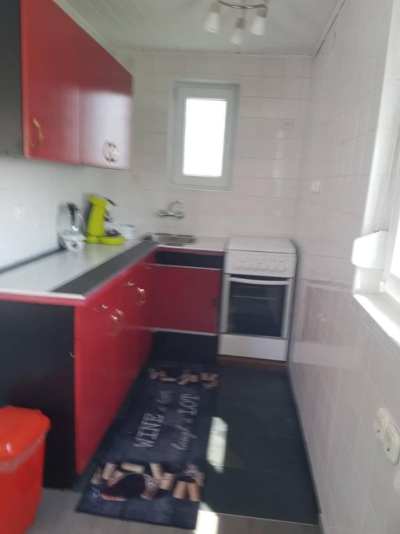 a kitchen with red cabinets and a black counter top at Napfény szálló in Galambok