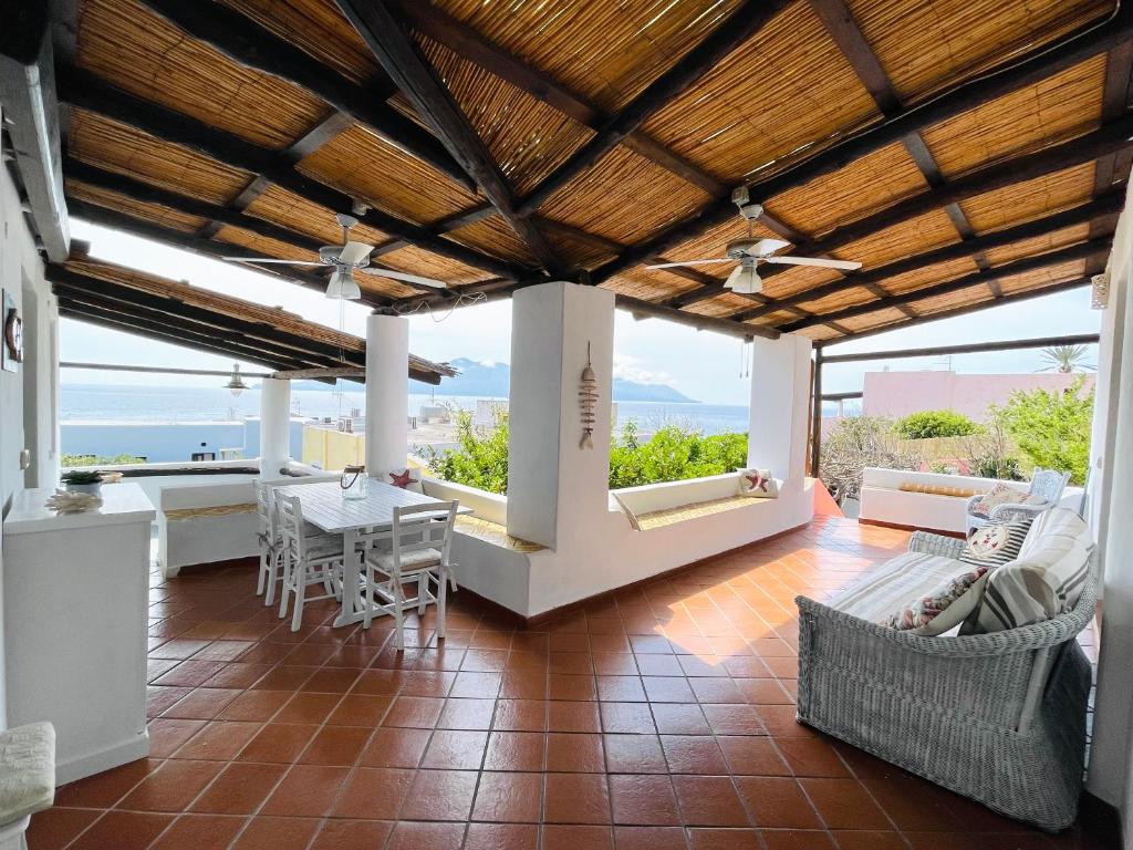 sala de estar de planta abierta con mesa y sillas en Villa Pomelia, Villa nel corso di Santa Marina Salina a 50 mt dal mare, en Santa Marina Salina