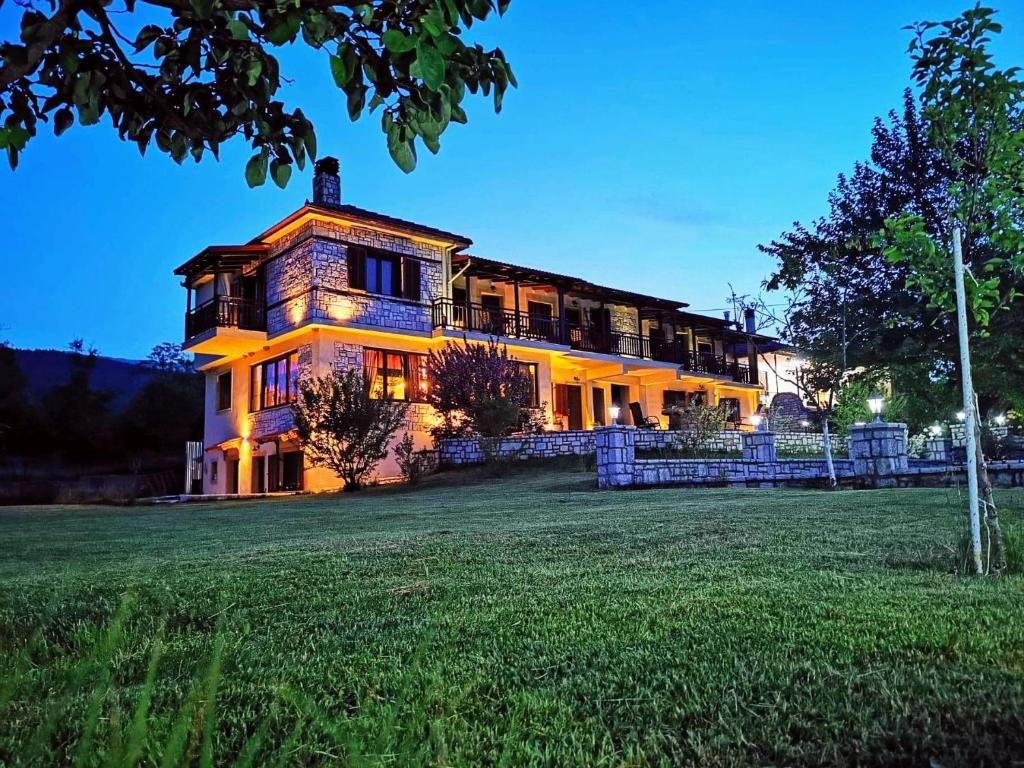 a large house sitting on top of a grass field at hostel lake plastira in Kalyvia