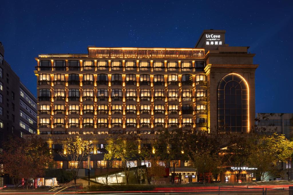a building with a lit up facade at night at UrCove by HYATT Hangzhou West Lake - Ten minutes walk to the West Lake in Hangzhou