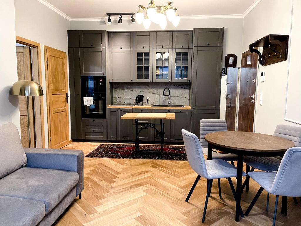 eine Küche und ein Wohnzimmer mit einem Tisch und einem Sofa in der Unterkunft Apartament Jodełka na Powiślu in Warschau