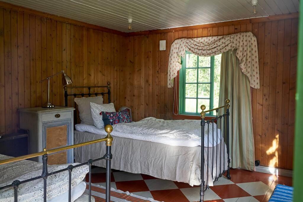 1 dormitorio con cama y ventana en Villa Leonore: Sommerhus m/strandlinje på Helgøya en Ringsaker