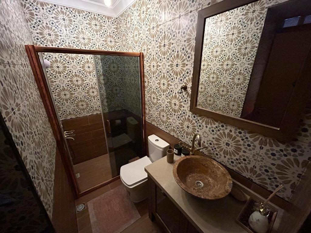 a bathroom with a sink and a toilet and a mirror at GorkyHouseUrla in Ildır