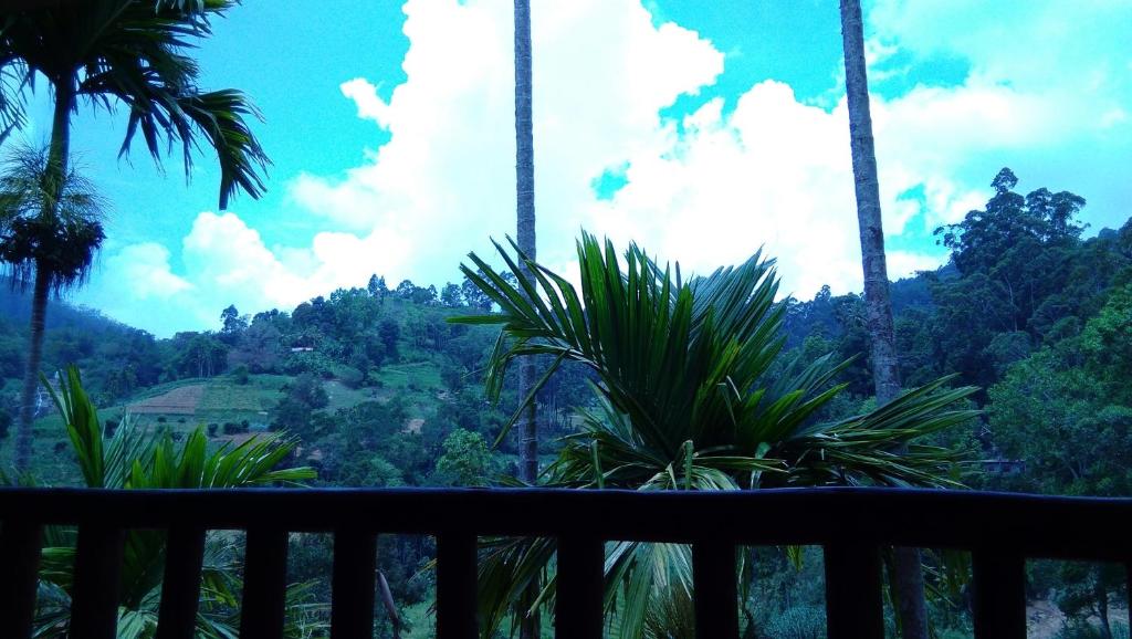 een balkon met palmbomen en uitzicht op een berg bij Marvellous Inn in Ella